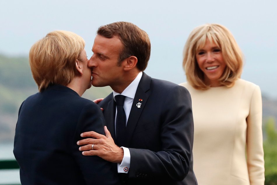 Emmanuel Macron kissing German Chancellor Angela Merkel